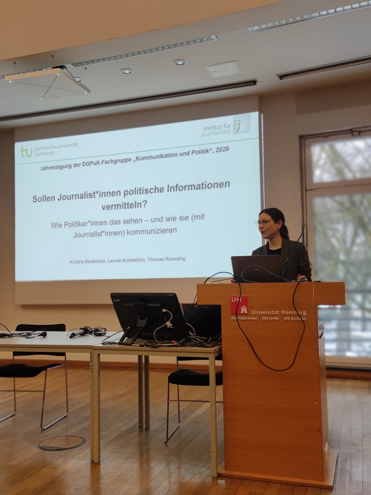 Kristina Beckmann steht an einem Rednerpult und hält einen Vortrag im Rahmen der Jahrestagung der DGPuK-Fachgruppe "Kommunikation und Politik".